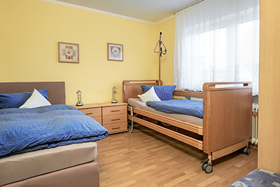 Schlafzimmer mit Einzelbett und Krankenpflegebett